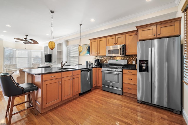 33 N Jefferson Ave, Margate, NJ 08402 - kitchen with stainless steel appliances, a peninsula, open floor plan, brown cabinetry, and light wood-style flooring
