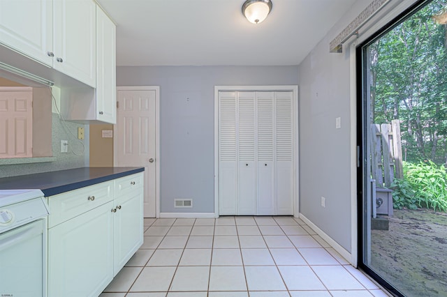 298 Mattix Run Unit 298, Galloway Township, NJ 08205 - kitchen featuring stove, dark countertops, white cabinets, light tile patterned flooring, and backsplash