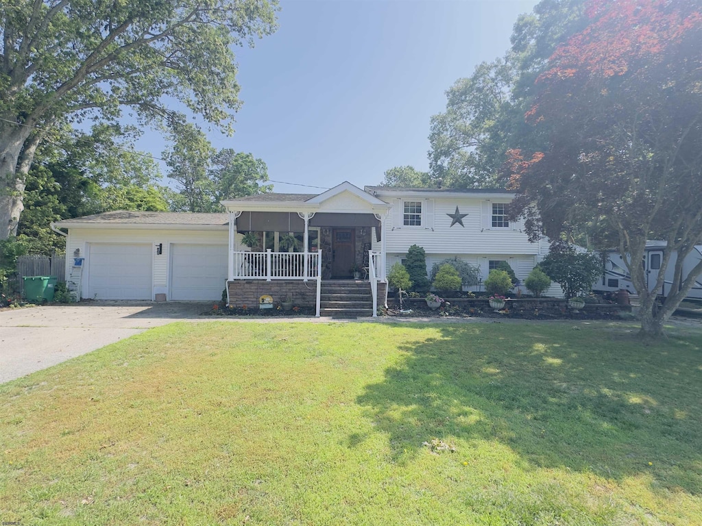 317 E Arbutus Ave, Galloway Township, NJ 08205 - tri-level home with a garage, a porch, concrete driveway, and a front yard