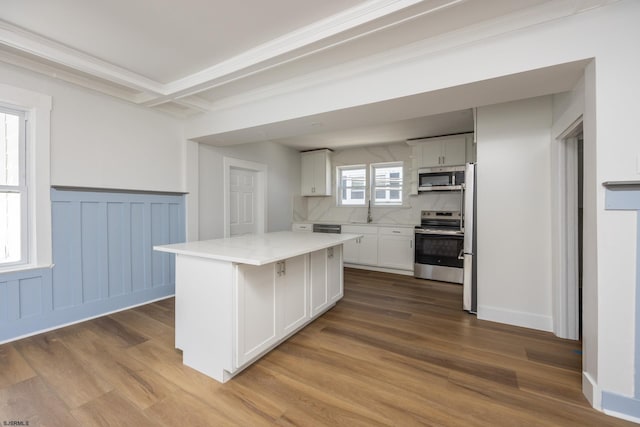412 11th St Unit 2, Ocean City, NJ 08226 - kitchen with appliances with stainless steel finishes, light countertops, white cabinets, a kitchen island, and wood finished floors