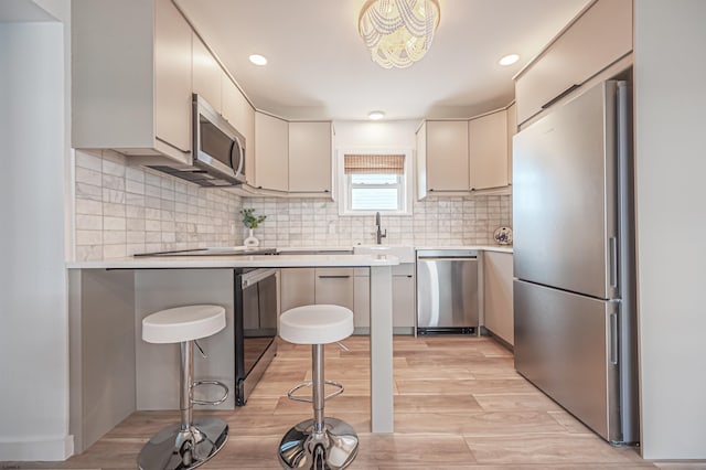 3801 Ocean Ave Unit 2, Brigantine, NJ 08203 - kitchen featuring appliances with stainless steel finishes, light countertops, light wood-style floors, decorative backsplash, and recessed lighting