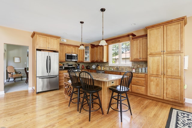 216 Castle Pine Dr, Egg Harbor Township, NJ 08234 - kitchen featuring stainless steel appliances, light wood-style flooring, a center island, a breakfast bar area, and tasteful backsplash