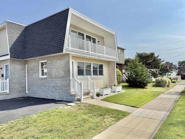 3400 W Brigantine Ave Unit 2, Brigantine, NJ 08203 - view of home's exterior featuring roof with shingles, brick siding, a balcony, entry steps, and a lawn
