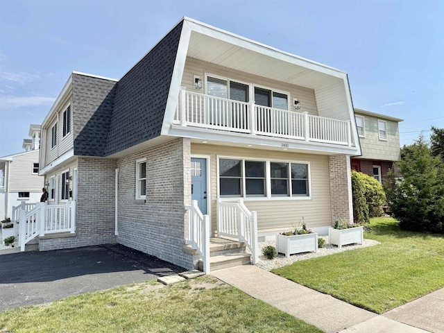 3400 W Brigantine Ave, Brigantine, NJ 08203 - view of front of property with a balcony, brick siding, roof with shingles, and a front lawn