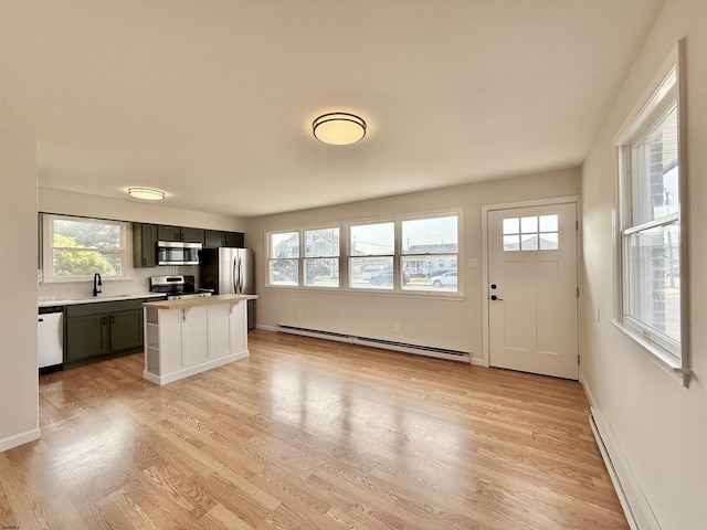 3400 W Brigantine Ave, Brigantine, NJ 08203 - kitchen with stainless steel appliances, a baseboard heating unit, light countertops, light wood finished floors, and a breakfast bar area