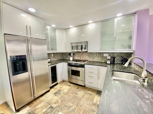 24 Coquille Beach Dr Unit 24, Brigantine, NJ 08203 - kitchen with stainless steel appliances, beverage cooler, white cabinetry, backsplash, and recessed lighting