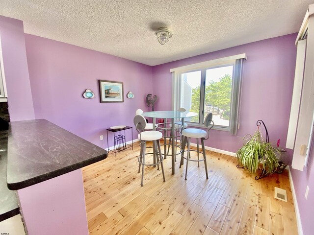 24 Coquille Beach Dr Unit 24, Brigantine, NJ 08203 - dining room with light wood-type flooring and a textured ceiling