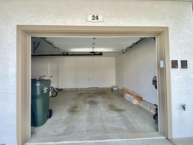 24 Coquille Beach Dr Unit 24, Brigantine, NJ 08203 - garage featuring a garage door opener and a textured wall