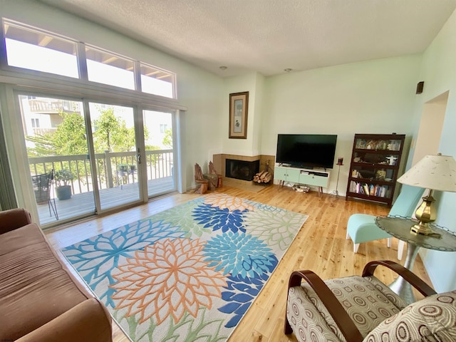 24 Coquille Beach Dr Unit 24, Brigantine, NJ 08203 - living area with hardwood / wood-style flooring, a tile fireplace, and a textured ceiling