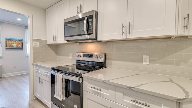 5000 Boardwalk Unit 107, Ventnor, NJ 08406 - kitchen featuring stainless steel appliances, white cabinetry, light wood finished floors, light stone counters, and tasteful backsplash