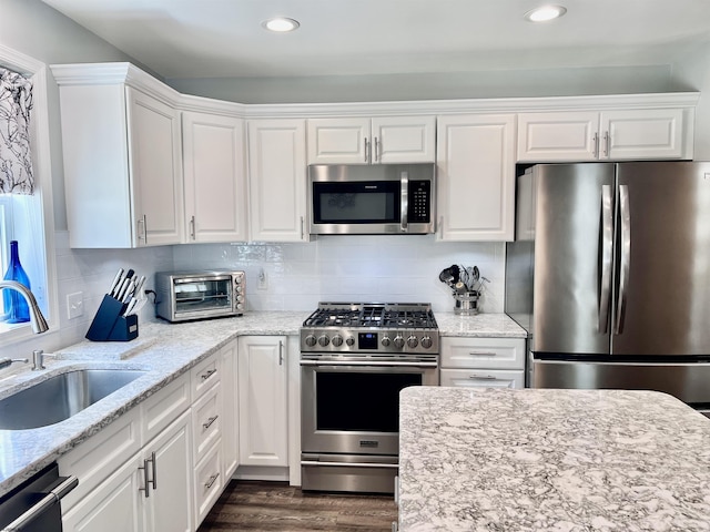 1304 Roberts Ave, Somers Point, NJ 08244 - kitchen with stainless steel appliances, white cabinets, dark wood-style floors, recessed lighting, and light stone countertops