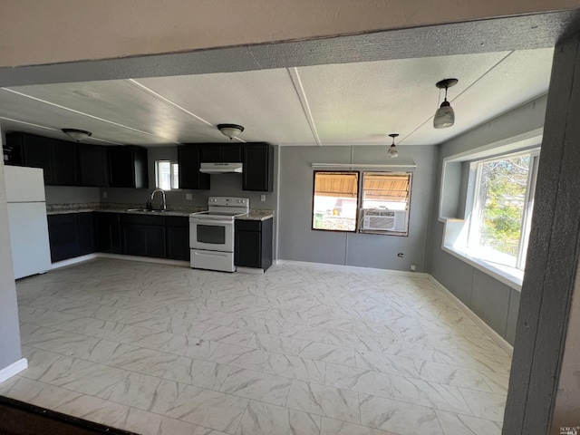 kitchen with white appliances, sink, light tile floors, decorative light fixtures, and a textured ceiling