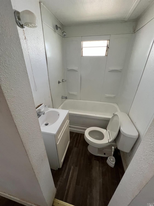 full bathroom with hardwood / wood-style flooring, toilet, tub / shower combination, vanity, and a textured ceiling