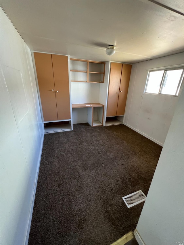 unfurnished bedroom featuring dark carpet