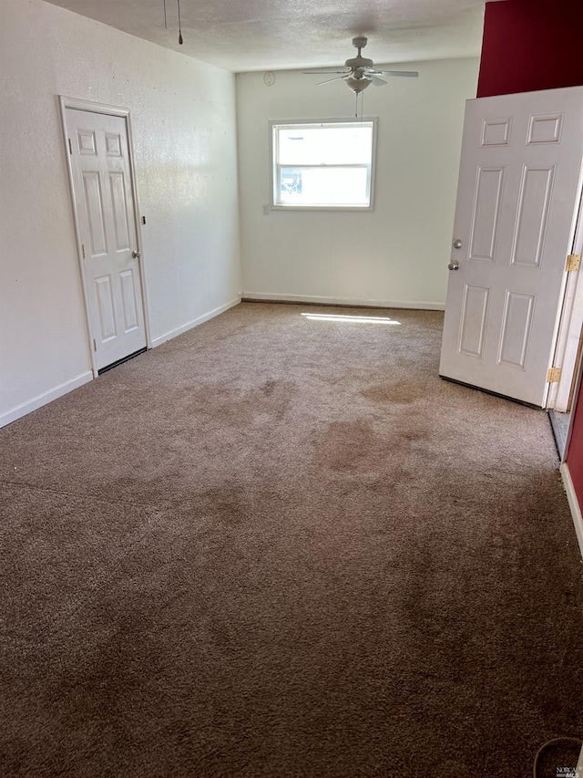 carpeted spare room featuring ceiling fan