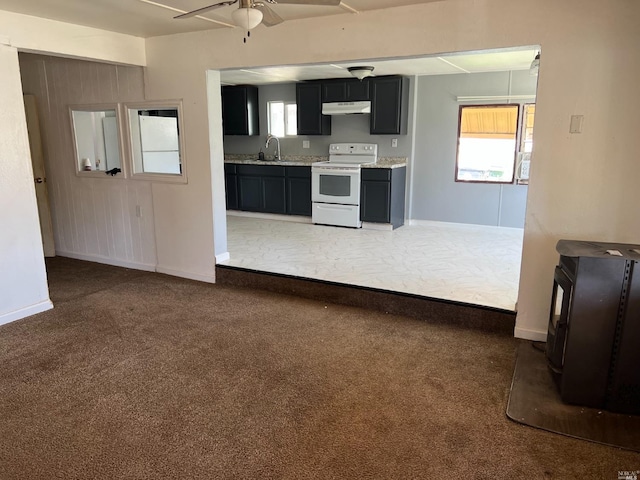 kitchen with ceiling fan, sink, dark colored carpet, light stone counters, and white electric range