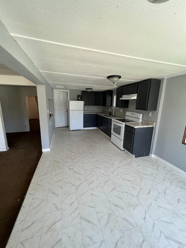 kitchen featuring white appliances, a textured ceiling, sink, and light tile floors