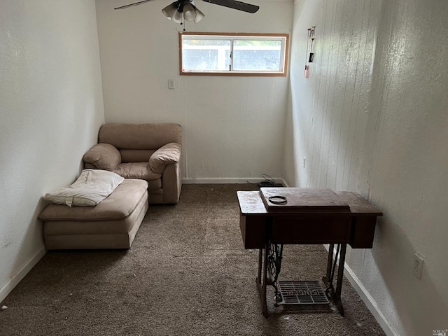 sitting room featuring ceiling fan and dark carpet