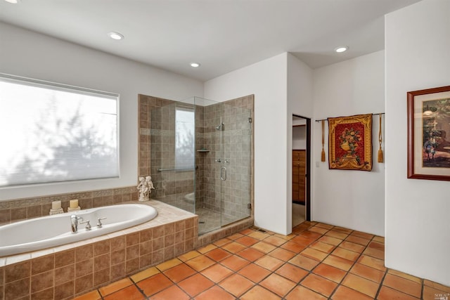 bathroom with tile flooring and separate shower and tub