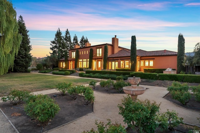 view of back house at dusk