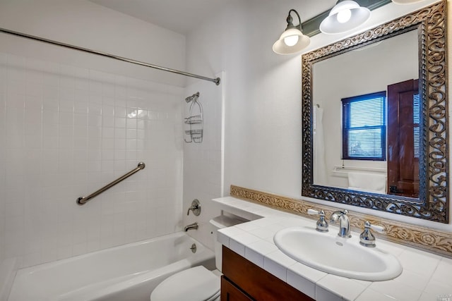 full bathroom with tiled shower / bath, toilet, and vanity