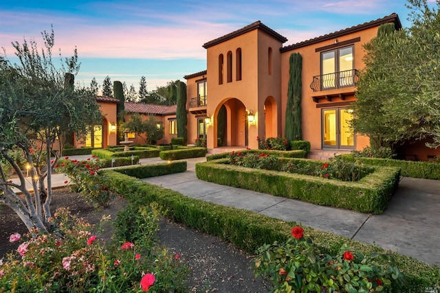 mediterranean / spanish-style home with a balcony and french doors