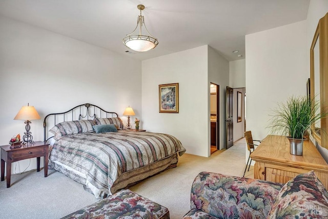 carpeted bedroom featuring ensuite bath