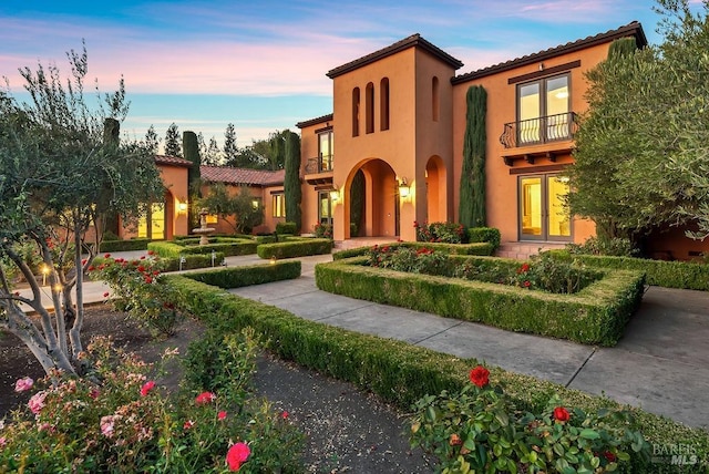 mediterranean / spanish-style house featuring a balcony and french doors