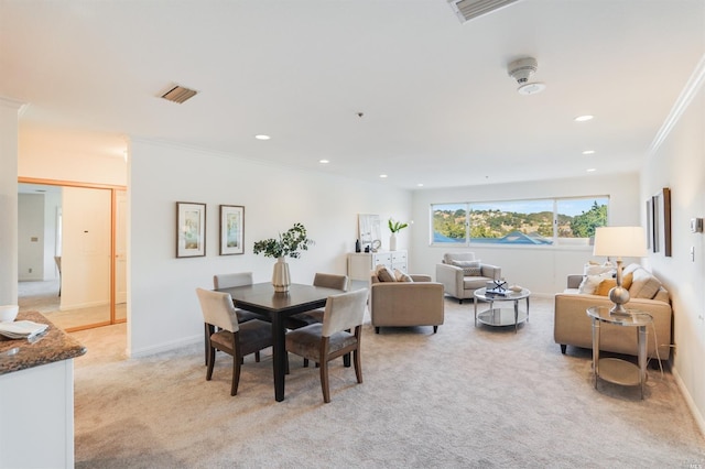 dining room featuring crown molding and light colored carpet