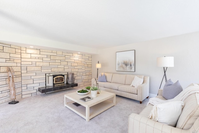 carpeted living room featuring a wood stove and a stone fireplace