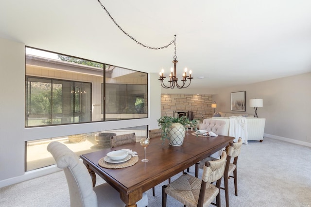 dining area featuring a chandelier, light colored carpet, and a brick fireplace