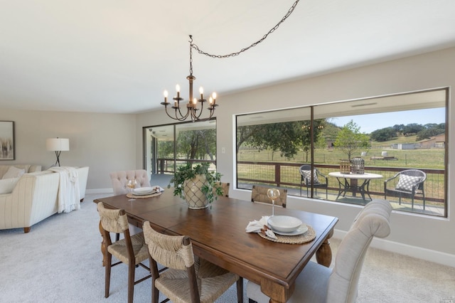 carpeted dining room featuring a chandelier