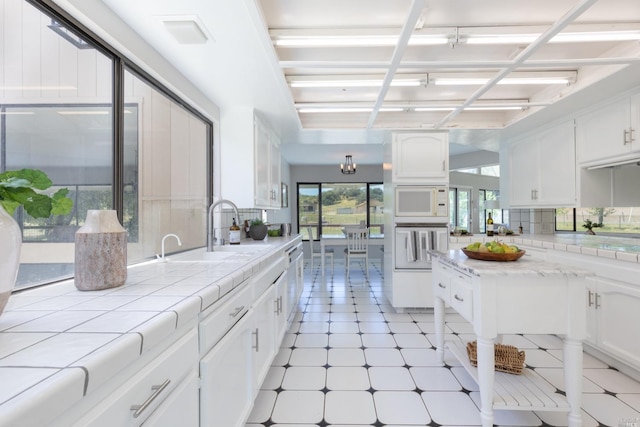 kitchen featuring white cabinetry and light tile floors