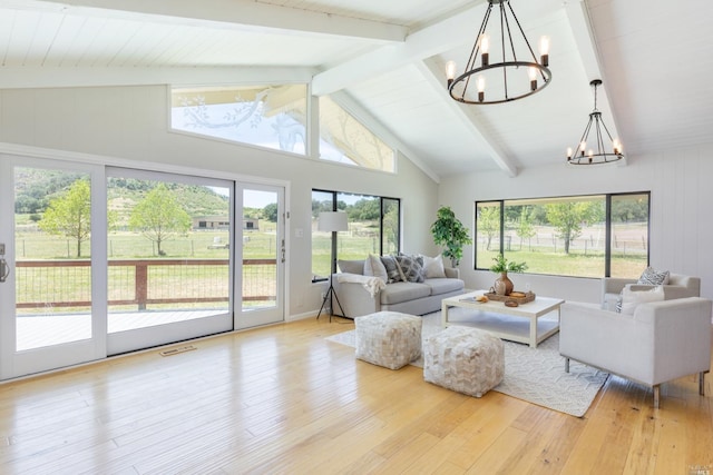 living room with beam ceiling, a notable chandelier, light wood-type flooring, and high vaulted ceiling