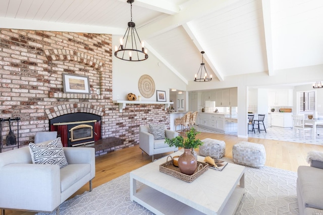 tiled living room with a notable chandelier, high vaulted ceiling, beam ceiling, brick wall, and a fireplace