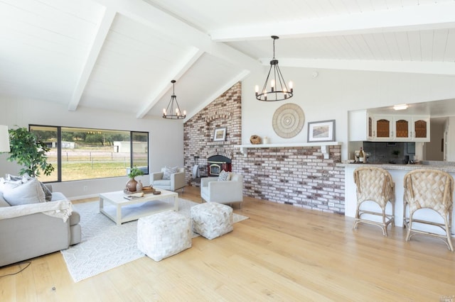 living room featuring a chandelier, high vaulted ceiling, beam ceiling, a fireplace, and light hardwood / wood-style flooring