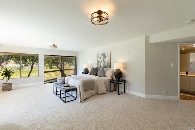 bedroom with light carpet and ensuite bath