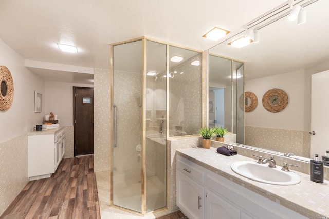 bathroom with an enclosed shower, vanity, and wood-type flooring