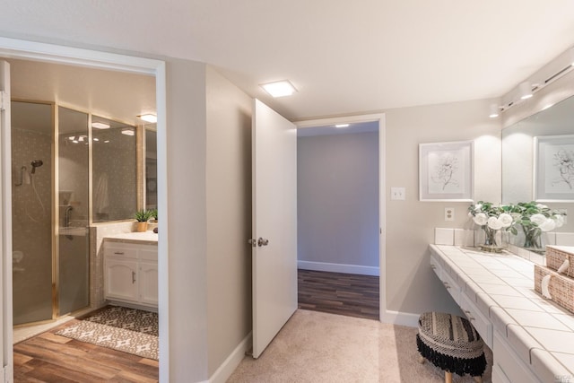 bathroom with vanity, hardwood / wood-style flooring, and a shower with shower door