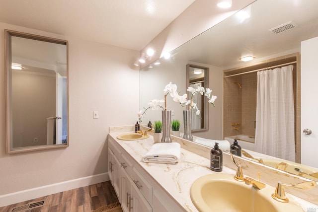 bathroom with shower / bath combo with shower curtain, hardwood / wood-style flooring, and dual bowl vanity