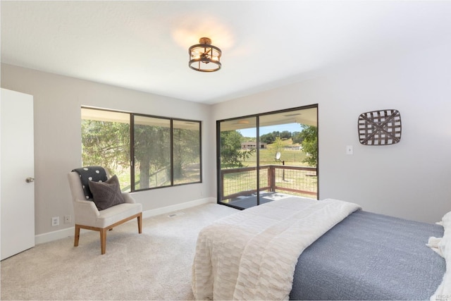 carpeted bedroom with multiple windows and access to exterior