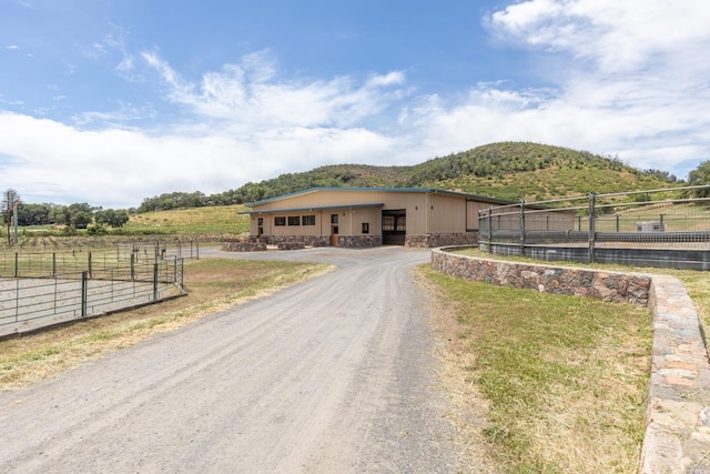 view of road with a rural view and a mountain view