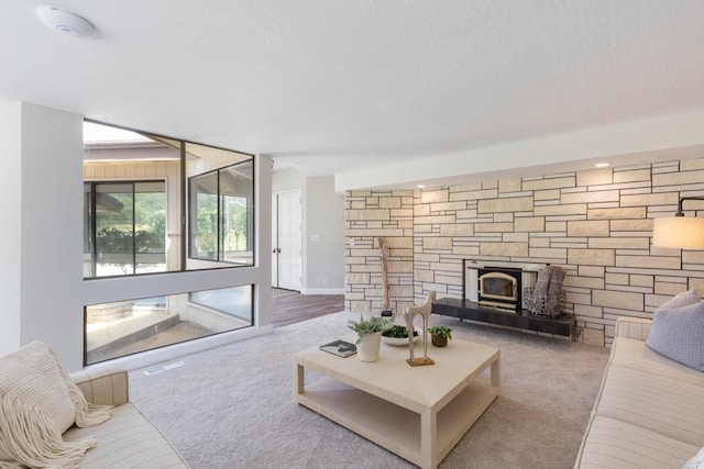 living room with carpet and a stone fireplace