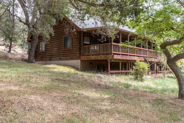 rear view of property with a wooden deck, crawl space, and log exterior