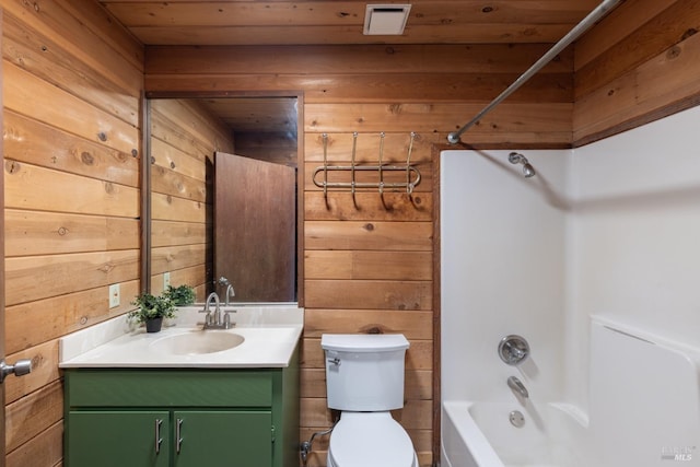 full bathroom featuring toilet, vanity, shower / bath combination, and wooden walls