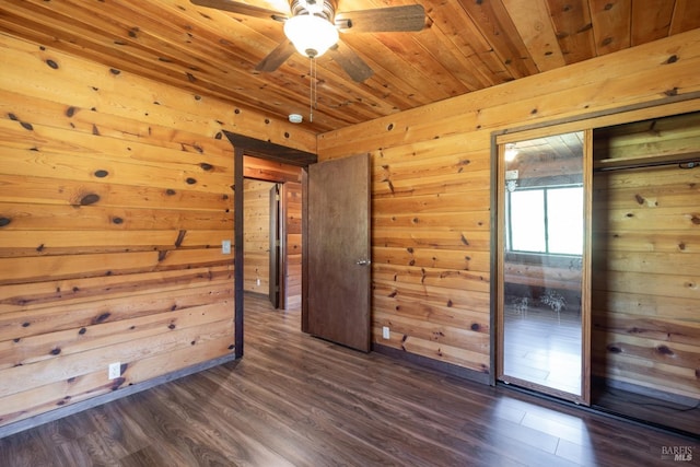 spare room featuring wood ceiling, wood walls, ceiling fan, and dark wood finished floors