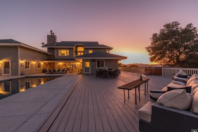 deck at dusk featuring an outdoor hangout area