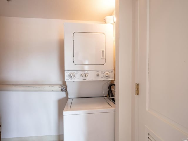 clothes washing area featuring stacked washer / dryer