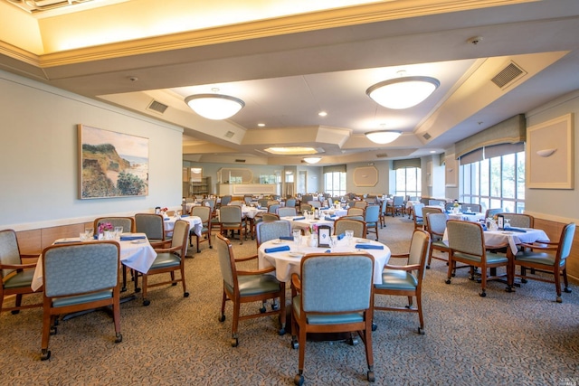 carpeted dining area with a tray ceiling