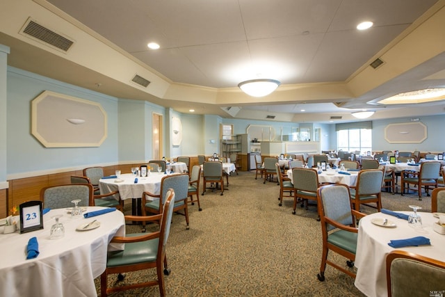 dining space with ornamental molding and carpet